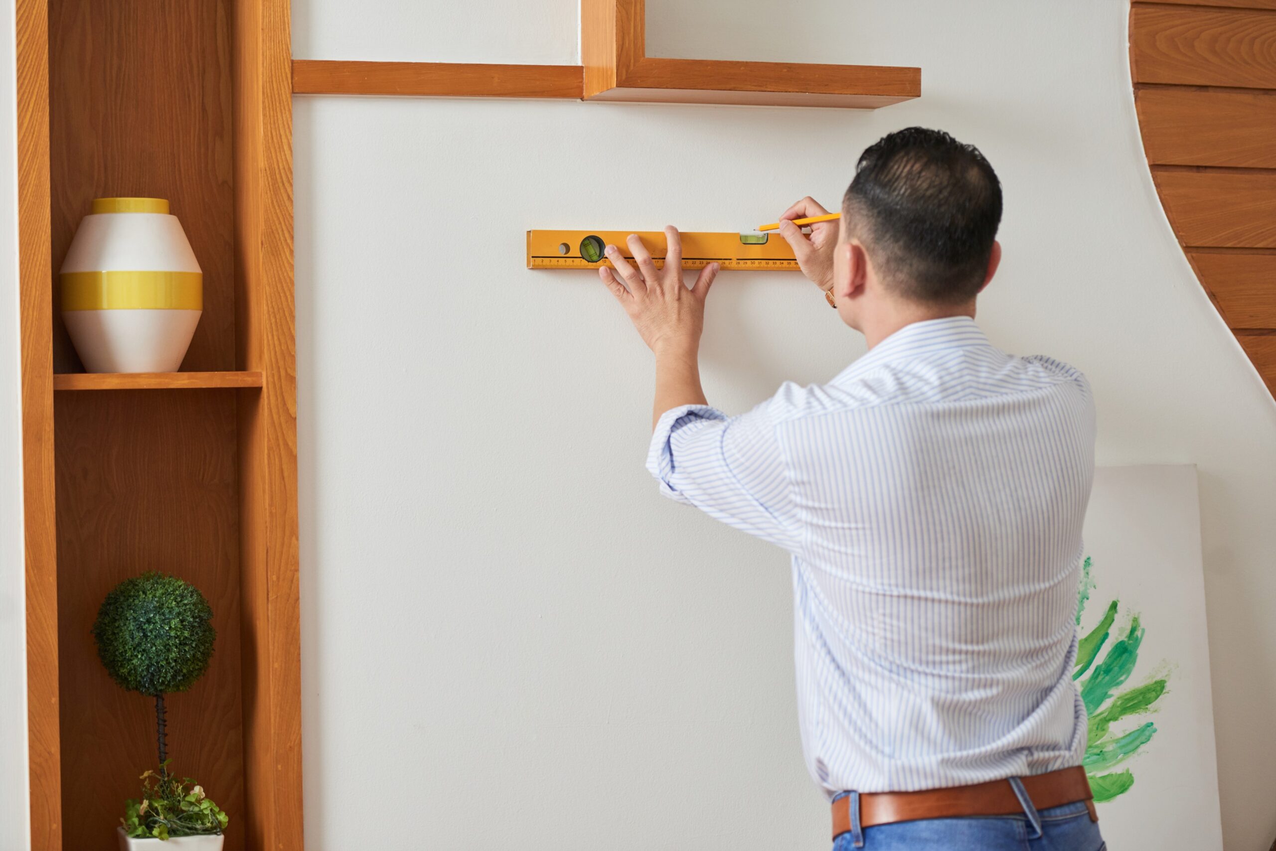 man-decorating-wall-with-picture (1)